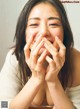 A woman covering her mouth with her hands.