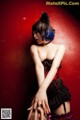 A woman with blue hair wearing a corset and stockings.