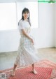 A woman standing on a rug in a room.