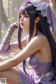 A woman in a purple dress sitting on the ground.