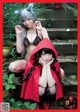 A woman in a red hooded cloak is posing next to another woman.