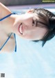 A woman in a blue bikini standing in a pool.