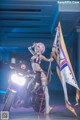 A woman in a bikini holding a flag next to a motorcycle.