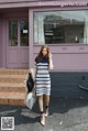 A woman standing in front of a purple building.