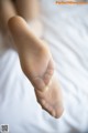 A close up of a person's feet on a bed.